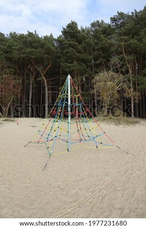 Colorful playground for kids. Sand beach Pirita in early spring with blue sky and white clouds. Pine forest on the back.