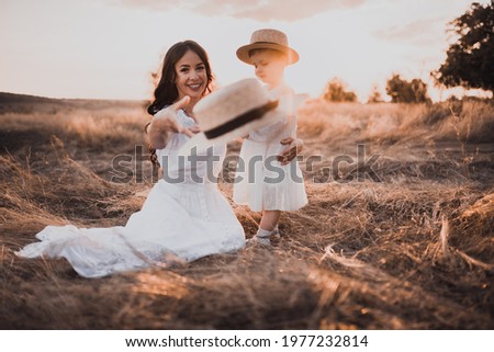 Happy smile family mother mom Straw boater hat child daughter having fun outdoors nature sunset summer. close up Portrait love couple baby girl together play walk rest child in arms parents kiss hug