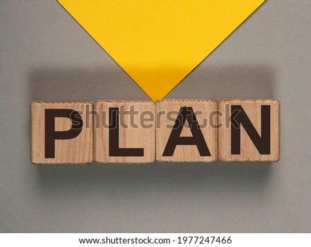 Plan word text on wooden dices on gray and yellow envelope background.