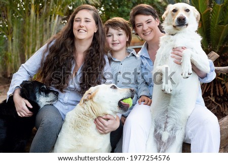 Lesbian moms with a young boy. 3 Labrador dogs. A big family picture. 