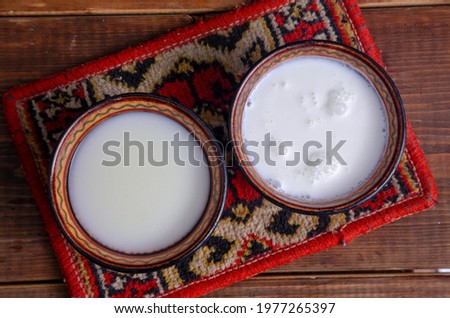 Mare and camel milk in bowls on a rustic background Royalty-Free Stock Photo #1977265397