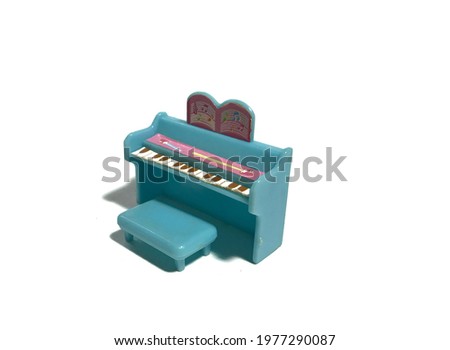 A tiny blue piano with small chair to sit with, along with the lyrics on top of the piano.