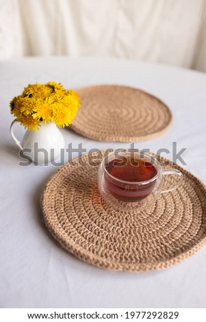 Dandelions and a cup of tea on the table, top view, flat lay. Break at work in the office in a comfortable environment, home comfort, good morning