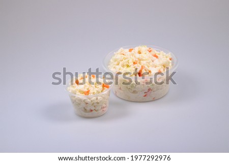 coleslaw at small and medium container transparent plastic in high res. image and isolated in white with a blurry ends