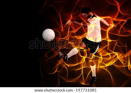 Football player in white kicking against abstract orange glowing black background