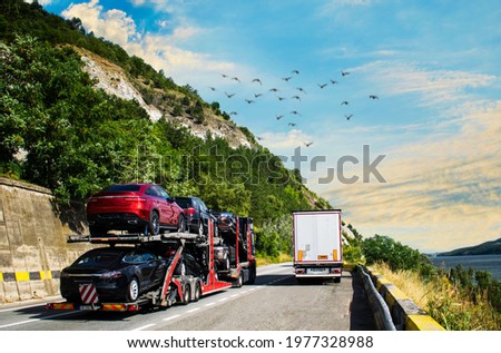 Car carrier transporter truck on road. Auto vehicles hauler on driveway- Overtaking the truck. No logo,brand. Royalty-Free Stock Photo #1977328988