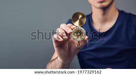 a man holding a compass in the room