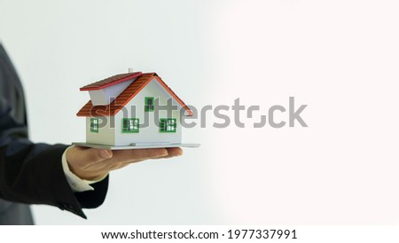Small house model in hand real estate agent white background