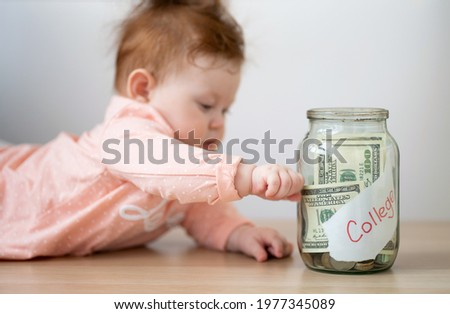 The kid is holding a piggy bank with the inscription college. Parents save money for the child's education.