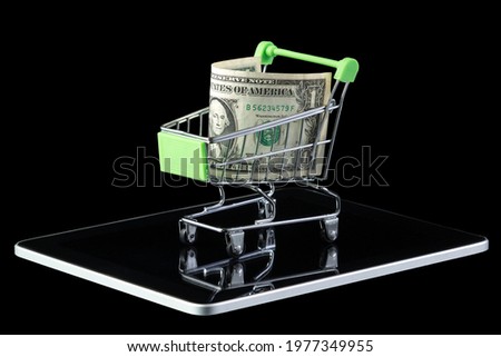 One dollar in a green shopping cart standing on a tablet