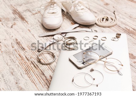 Female accessories with laptop and mobile phone on white wooden background