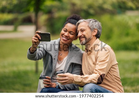Beautiful lovers, taking picture with phone, enjoying in coffee outside.