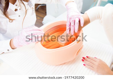 process paraffin treatment of female hands in beauty salon Royalty-Free Stock Photo #1977420200