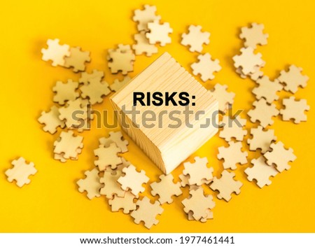 RISK. puzzles and wooden cubes with the text on a YELLOW background. Concept for management and business.