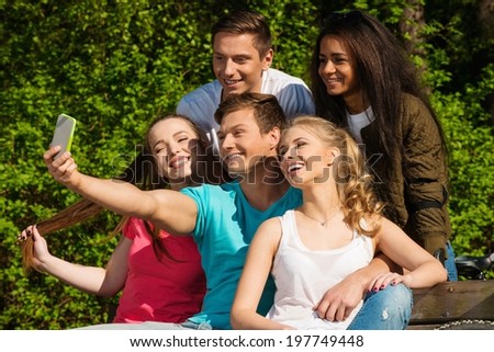 Multi ethnic group of sporty teenage friends in a park taking selfie
