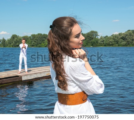 Girl waiting for her boyfriend who is willing to give her dream. The guy holding the boat with red sails. Assol and Gray. Red Sails.