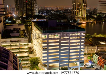 parking building along river in bangkok, view illuminated by night