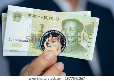 Focus select and blur Dogecoin doge and Chinese Yuan 1 one RMB, CNY with Crypto currency on hand business man wearing a blue suit. Filed and put and give to me. Close up and Macro photography concept