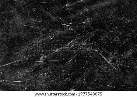 Scratches and dust on black background. Vintage scratched grunge plastic broken screen texture. Scratched glass surface wallpaper. 