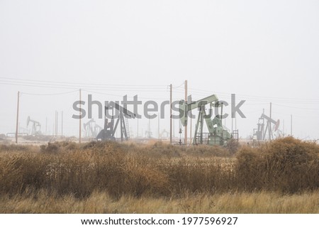 Oil well pump jacks pumping crude oil for fossil fuel energy