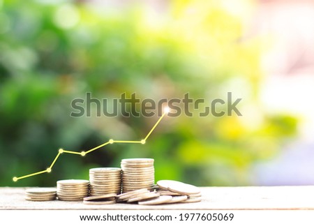 The higher graph on top of a pile of coins with blurred green nature background, Money growing concept and sustainable investment, Business success and financial concept, Banking and economy idea