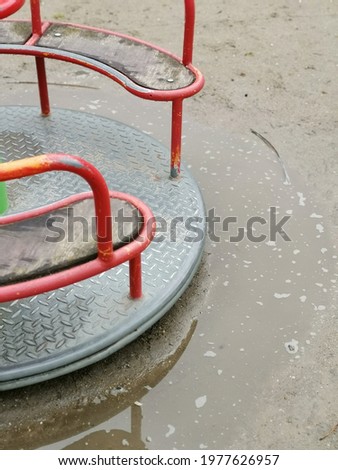 A part of a red baby swing after the rain