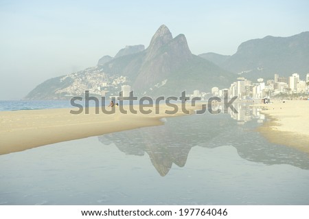 Misty puddle reflection of Rio de Janeiro Ipanema Beach Brazil with Two Brothers Dois Irmaos Mountain city skyline