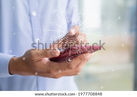 Hands holding digital tablet, smartphone with keyboard and computer laptop. Digital marketing media in virtual screen with icon. Concept of digital marketing media.
