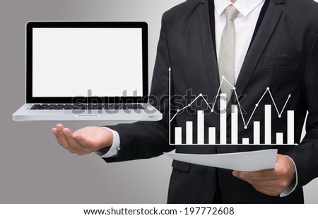 Businessman standing posture hand hold laptop showing graph isolated on gray background