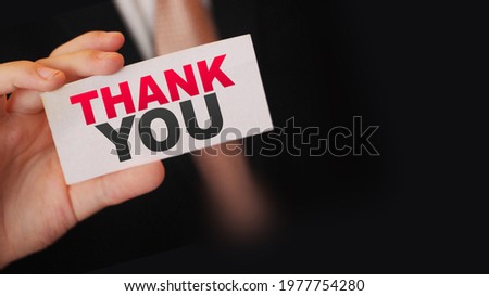 Thank you words on a card in businessman's hand. Business concept.