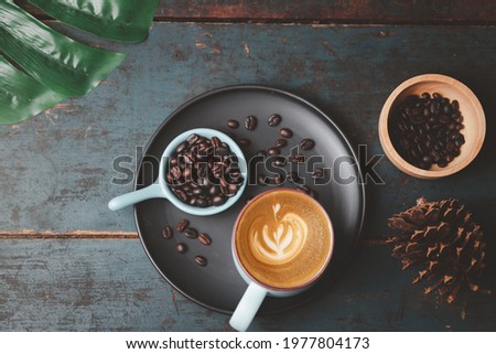 Top view of hot coffee latte in heart shape on a blue vintage wooden table
