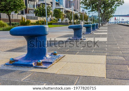 A row of blue marine bollards used as decoration on the boardwalk at Yarra's Edge in Melbourne, Australia