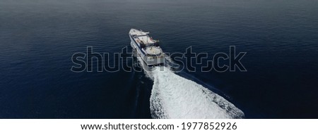 Aerial drone ultra wide photo of high speed passenger ferry cruising in high speed in Aegean deep blue sea, Greece Royalty-Free Stock Photo #1977852926
