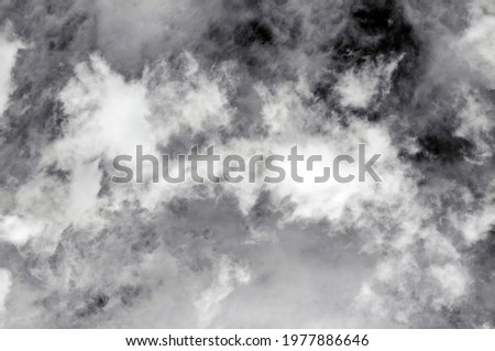 blue sky with dark black, gray and white clouds with background texture