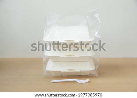 Plastic bags and food containers on wood table. Food delivery service. 