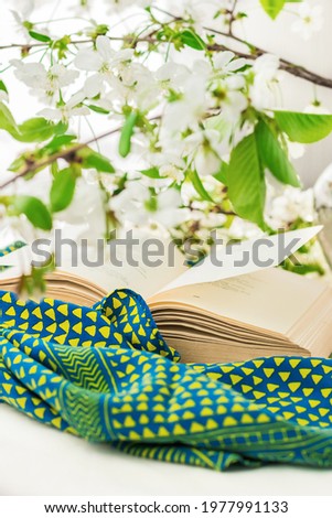 Open book and blooming spring branches on a white background. Glass vase with flowers. Good morning lifestyle, slow life concept.