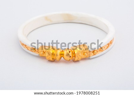 Bangle made with a gold and plastic. Isolated on white background. Jewelry stock photo. White color bangle. Top view.