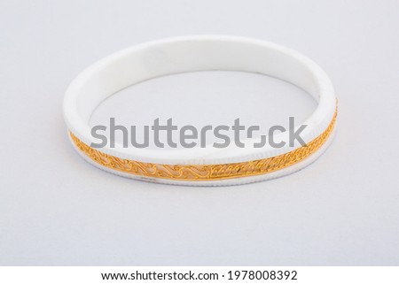Bangle made with a gold and plastic. Isolated on white background. Jewelry stock photo. White color bangle. Top view.