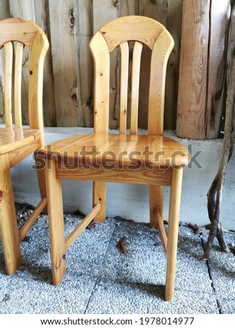 Old used wooden farm chairs in a shelter on a farm.