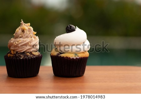 Delicious mini Cupcake on a light wooden table. Horizontal image. Blurred background.