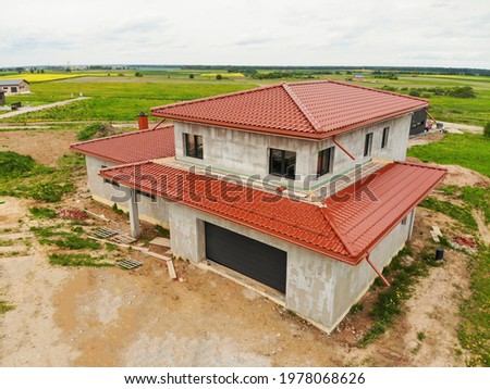 House with red roof tiling aerial view during summer