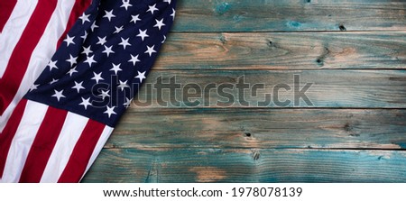 Waving American flag on left side of faded blue wooden planks for happy memorial or Independence Day background concept 