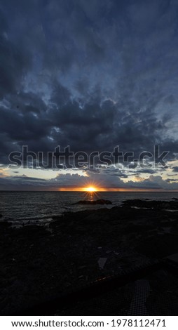 Sunset pictures with lots of clouds and rocks by the sea give a feeling of sadness, perfect for making wallpapers