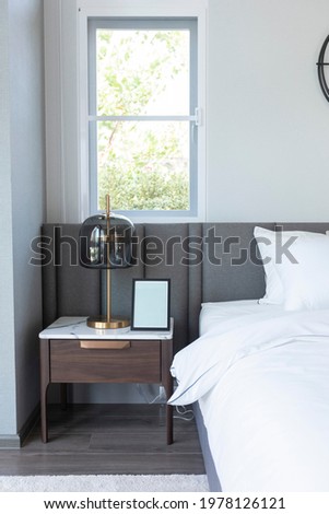 Black and white Bedroom interior with side table lamp and wall clock.