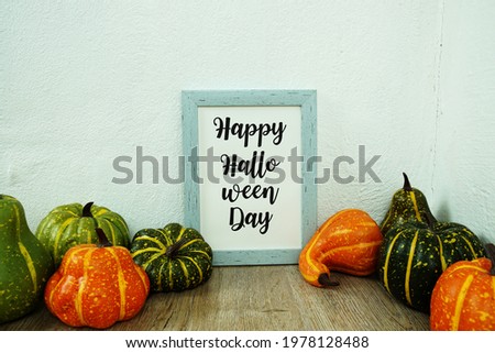 Happy Halloween Day typography text with pumpkin decoration on wooden table