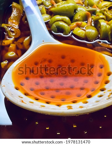 photo of spoon in pickled olives with oil dish