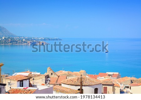 Sea views, tiled roofs and a sailboat in the distanceSea views, tiled roofs and a sailboat in the distance, horizontal format