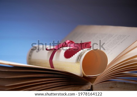 scroll of certificate on open book              