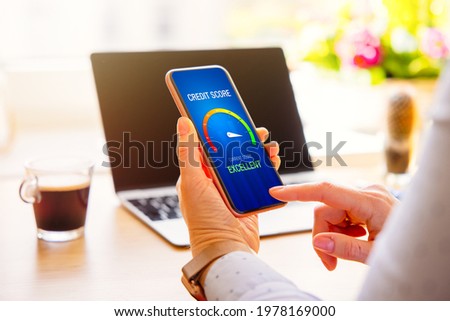 Woman looking at her credit score result on mobile phone Royalty-Free Stock Photo #1978169000