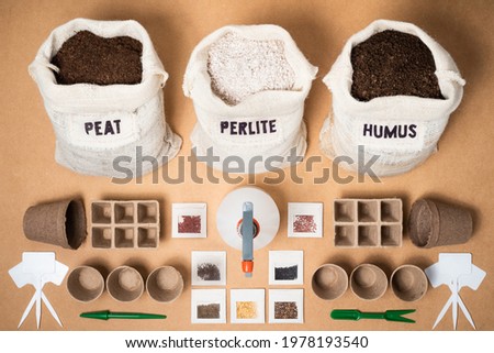 A complete eco-friendly biodegradable seed starting kit, with peat moss, perlite and worm humus for a potting soil mix, peat trays, pots, an atomizer, plant labels, and different seeds. Royalty-Free Stock Photo #1978193540